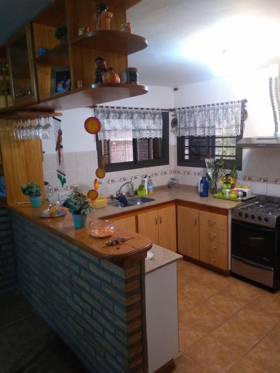 Excelente Chalet, listo para entrar, 2 dormitorios, Living-comedor con hogar a leña, cocina amplia, lavadero cubierto, quincho-cochera con deposito, aberturas de madera, techo con tejas. — foto 13